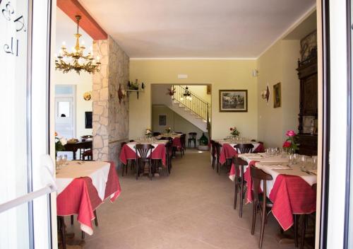 un restaurante con mesas con manteles rojos. en Agriturismo Il Borgo, en Passo di Mirabella