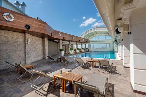 un patio al aire libre con mesas y sillas y una piscina en Ramada Plaza By Wyndham Istanbul City Center en Estambul