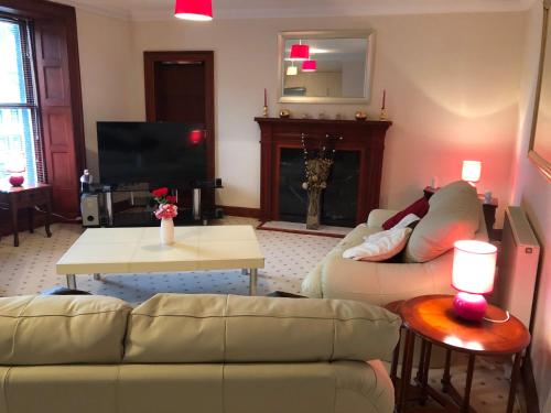 a living room with two couches and a tv at Executive Serviced Apartments 1 in Forfar