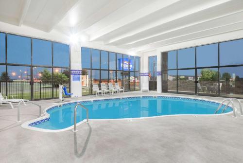 a large swimming pool in a building with windows at Baymont by Wyndham Springfield South Hwy 65 in Springfield