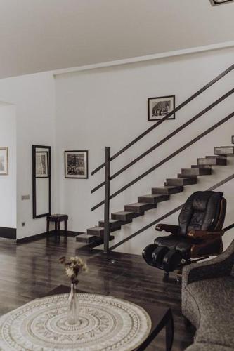 a living room with a chair and a table and stairs at Millennium Tbilisi in Tbilisi City