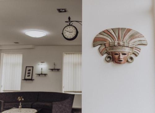 a room with a clock and a statue of a head on the wall at Millennium Tbilisi in Tbilisi City