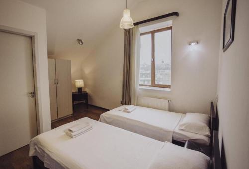two beds in a room with a window at Millennium Tbilisi in Tbilisi City