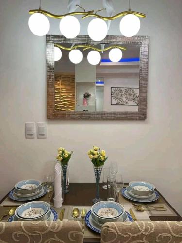a dining room table with plates and a mirror at Romantic Studio Unit, Matina Enclaves Residences in Davao City