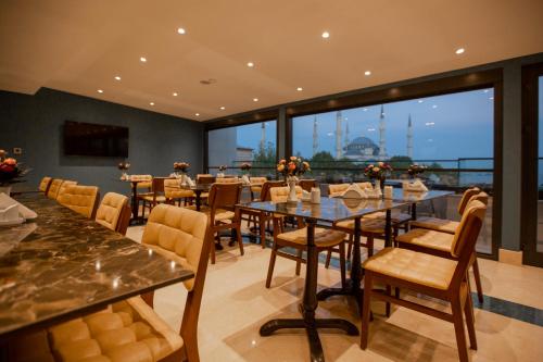 a restaurant with tables and chairs and a large window at HaciBayramHotel in Istanbul