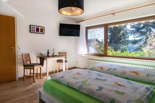 1 dormitorio con cama, mesa y ventana en stuub simonswinkel en Friedenweiler