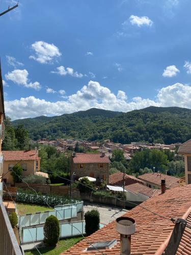 a view of a town with mountains in the background at Apartamento acogedor in Sant Joan de les Abadesses