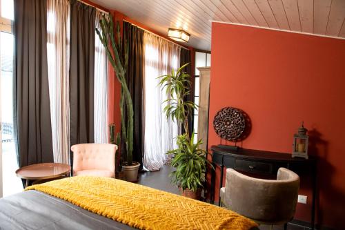 a bedroom with orange walls and a bed and plants at Boutique B&B and Wellness la Casa dei 5 Elementi in Giubiasco