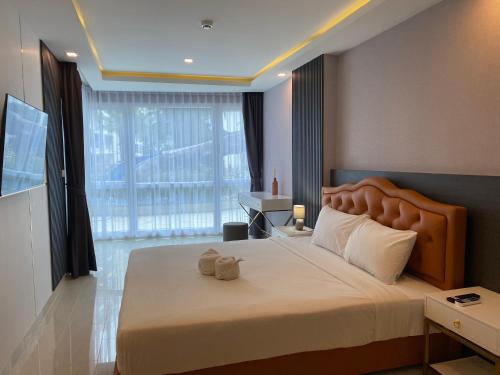 a bedroom with a large bed with a large window at Grand Avenue Condo by Bormon in Pattaya Central