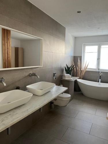 a bathroom with two sinks and a tub and a toilet at Luxus Villa Hannover Messe in Hannover