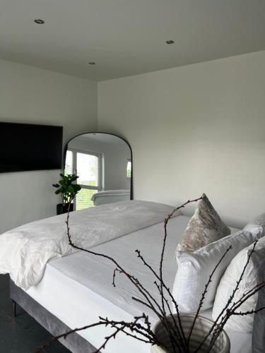 a white bedroom with a large bed with a mirror at Luxus Villa Hannover Messe in Hannover