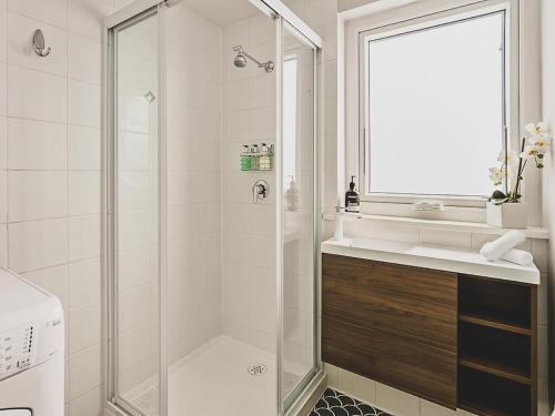 baño blanco con ducha y lavamanos en Rose Court Apartments "Astera", en New Town