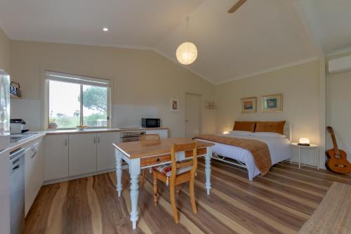 a kitchen and a bedroom with a bed and a table at Meander Retreat - Garden Studio with dog park in Springton