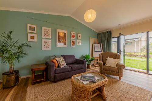 a living room with a couch and a chair at Meander Retreat - Garden Studio with dog park in Springton