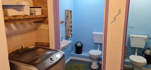 Baño pequeño con 2 aseos y lavamanos en Sunset beach backpackers, en Bloubergstrand