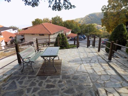 a patio with two benches and a table at Hotel Complex Pierion Musses in Elatochori