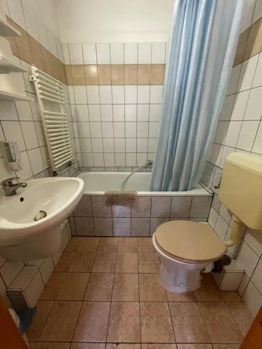 y baño con lavabo, aseo y bañera. en Katalinkert Panzió, en Győr