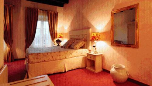 a bedroom with a bed and a mirror and a window at Villa Baroni in Lomnago