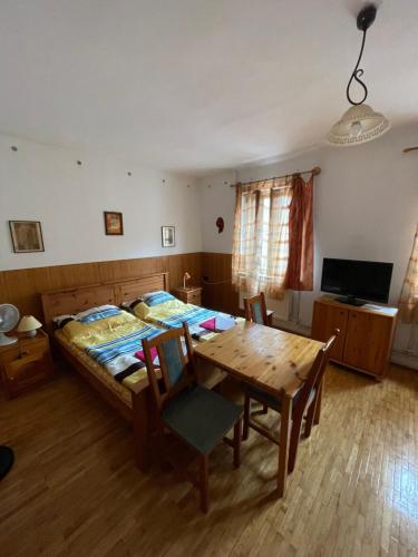 a bedroom with a bed and a wooden table and chairs at Katalinkert Panzió in Győr