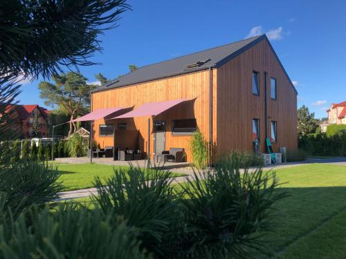 an orange barn with an awning in a yard at Rafa Międzywodzie in Międzywodzie