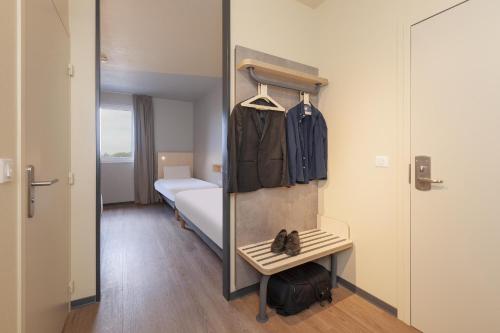 a room with a bedroom with a bed and a mirror at Ibis Budget Mont De Marsan in Mont-de-Marsan