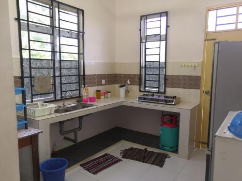 a kitchen with a sink and two windows at UMMI'S Homestay Besut in Kuala Besut