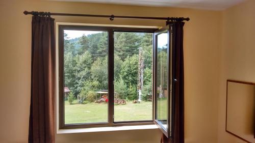 a window with a view of a yard at Rusaliite Adventure House in Bachevo