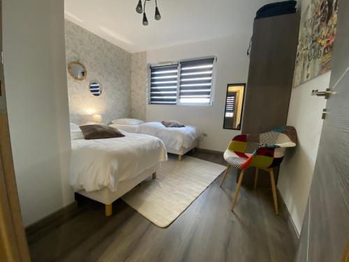 une chambre avec deux lits, une table et une chaise dans l'établissement 