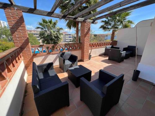 a patio with chairs and tables on a balcony at Casa con piscina en el centro de Marbella. in Marbella