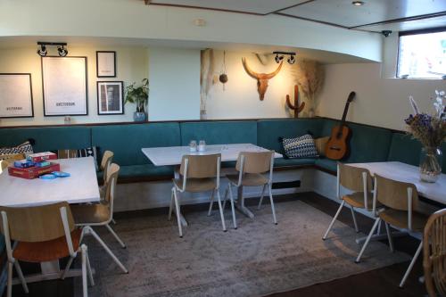 un restaurante con mesas y sillas y una guitarra en la pared en FLOW en Ámsterdam