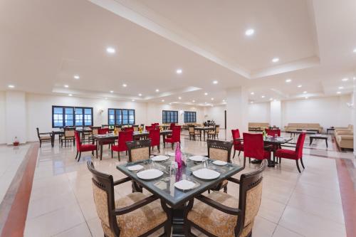 a large dining room with tables and red chairs at Shree Vallabh Vilas Lords Plaza in Eklingji