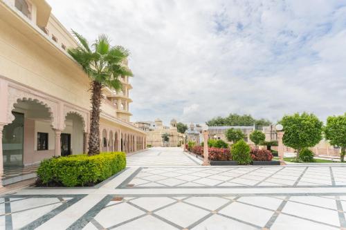 a palm tree in the middle of a courtyard at Shree Vallabh Vilas Lords Plaza Nathdwara - Pure Veg in Eklingji