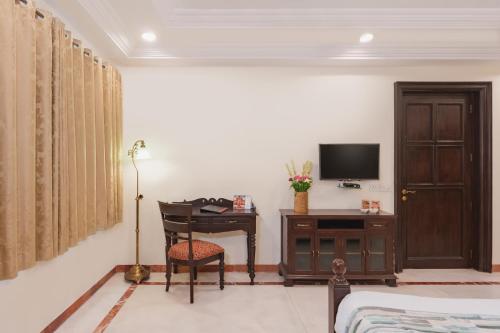 a bedroom with a desk and a bed and a television at Shree Vallabh Vilas Lords Plaza Nathdwara - Pure Veg in Eklingji