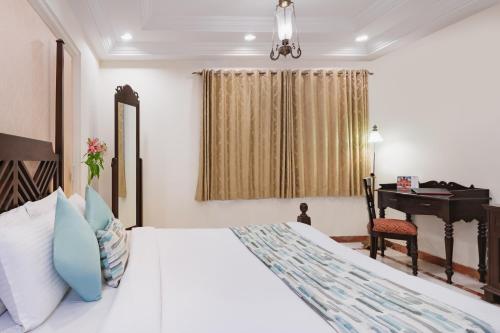a bedroom with a white bed and a piano at Shree Vallabh Vilas Lords Plaza Nathdwara - Pure Veg in Eklingji