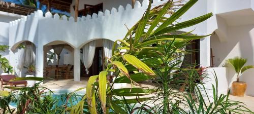 a group of plants in a room with a pool at Namayani apartment in Pwani Mchangani
