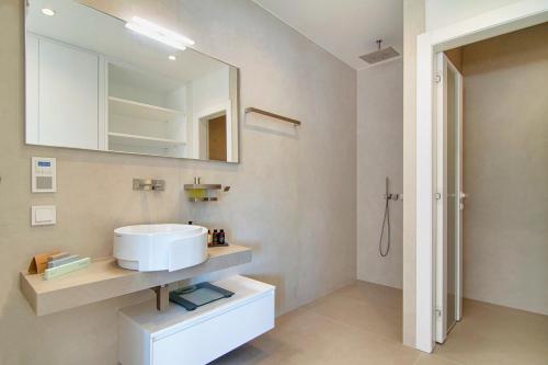 La salle de bains est pourvue d'un lavabo et d'un miroir. dans l'établissement LIVINGHOME SUITES, à Parga
