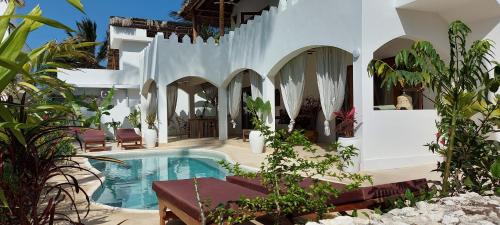 a house with a swimming pool in a courtyard at Namayani apartment in Pwani Mchangani