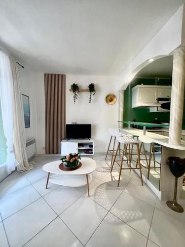 - un salon avec une table et un mur vert dans l'établissement Idéal Congrès - 1 min Mer - WIFI - hyper - centre, à Cannes