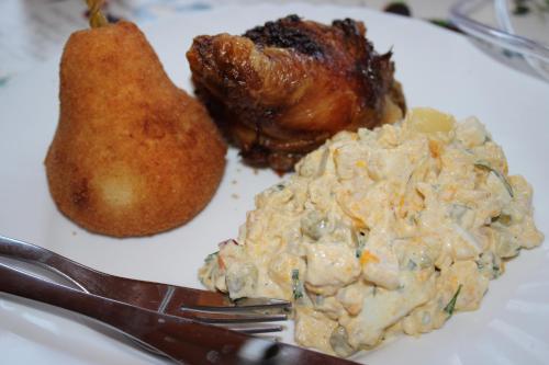a plate of food with chicken and potato salad and a fork at Gospodarstwo Agroturystyczne Agroletnica in Świdnica