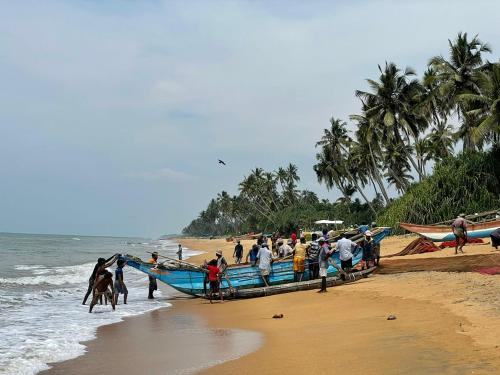 a group of people on a boat on the beach at Little Villa Hotel in Wadduwa