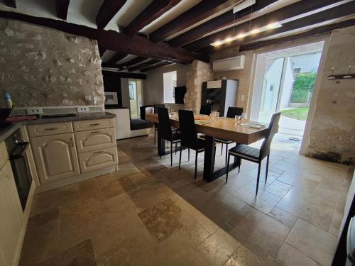 une cuisine avec une table et des chaises dans une pièce dans l'établissement Le pigeonnier - proche Beauval & châteaux, à Seigy