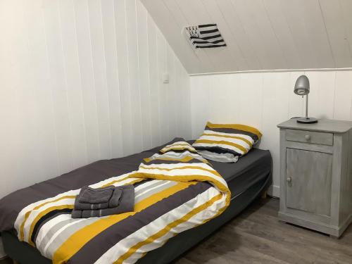 a bedroom with a bed and a table with a lamp at La petite maison terre mer in Plélo