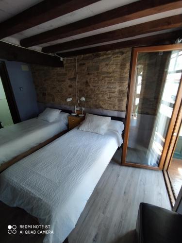 a bedroom with two beds and a large mirror at Casa Apilladeira in Puentedeume