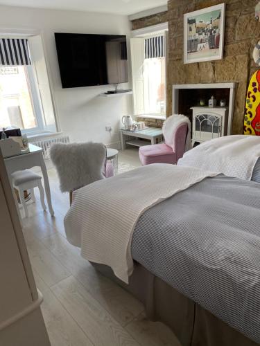a bedroom with a bed and chairs and a fireplace at Coastal Joy - Family and friends bedrooms in Newbiggin-by-the-Sea