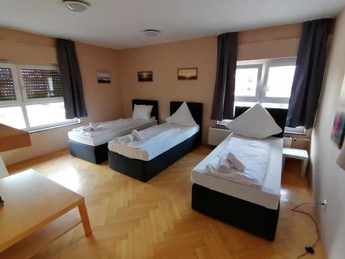a hotel room with two beds and a table at La Stella in Süßen