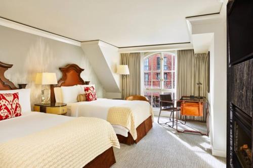 una camera d'albergo con due letti e una televisione di Aspen St Regis Resort Hotel Room With 2 Queens ad Aspen