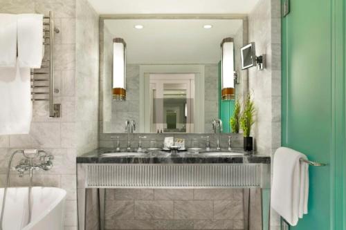 un bagno con due lavandini e un grande specchio di Aspen St Regis Resort Hotel Room With 2 Queens ad Aspen