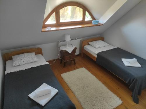 a small room with two beds and a window at Deák Vendégház Dörgicse in Dörgicse