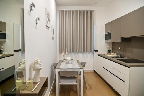 a kitchen with a small table and a white kitchen at Floris Pompei in Pompei