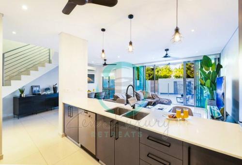 een keuken met een wastafel en een woonkamer bij ZEN ARCTIC Luxury 2-Story T/House + Pool & Markets in Fannie Bay